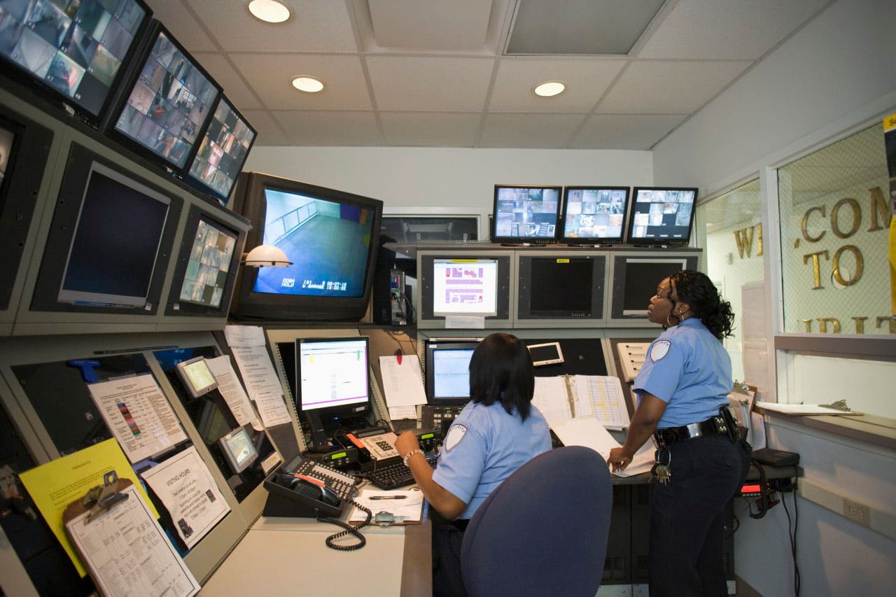 Security guards watching surveillance cameras