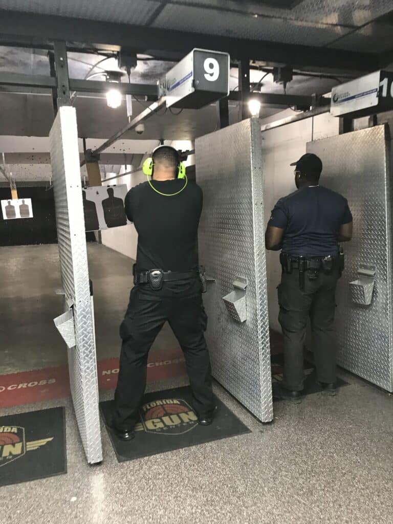 Two men shooting at an indoor shooting range