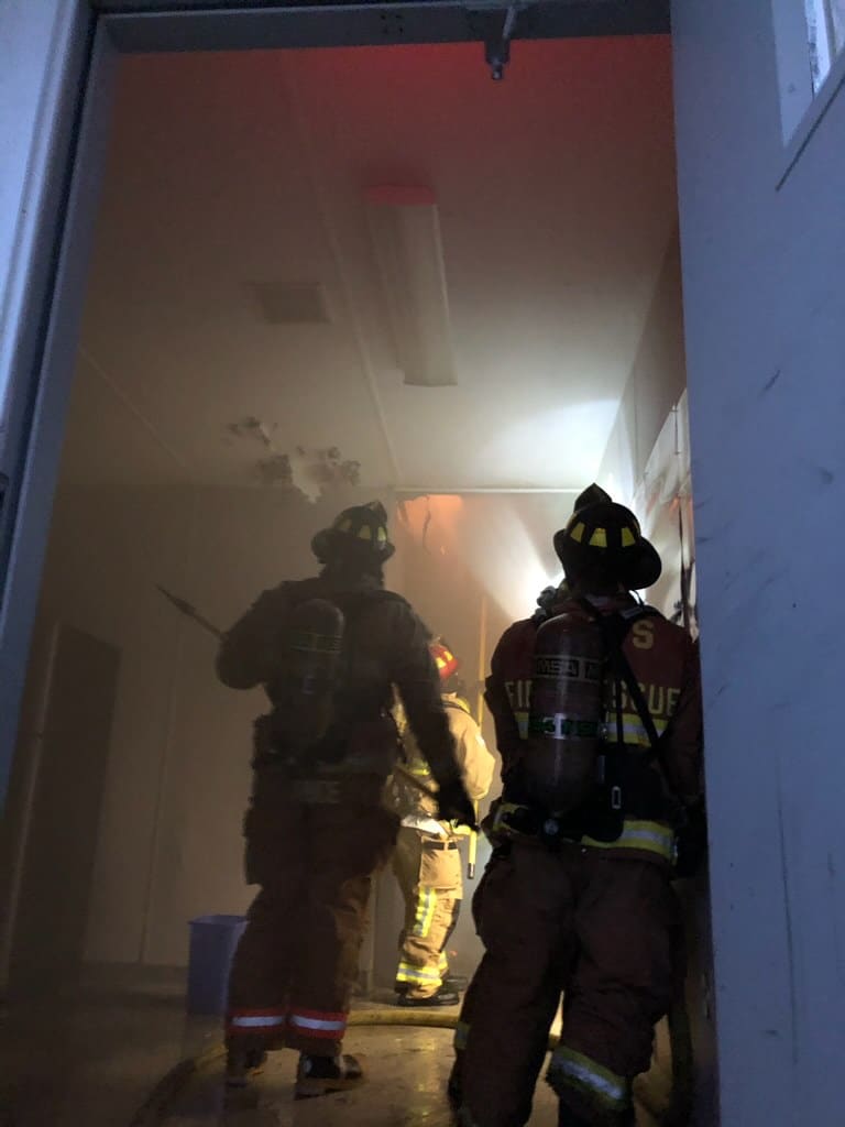 Team of firefighters dousing a fire inside a building