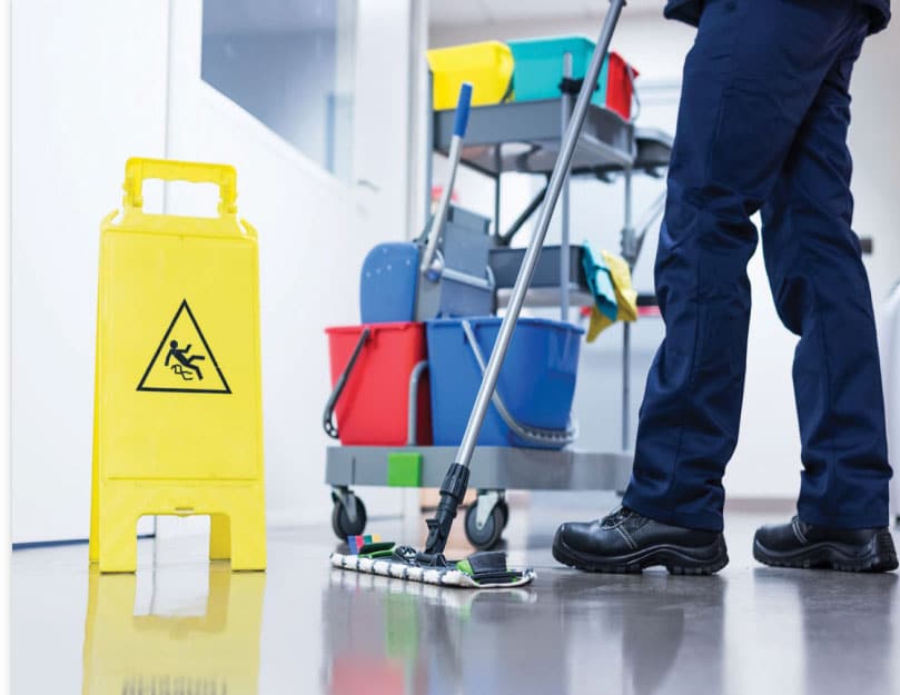 Man mopping next to caution floor wet sign