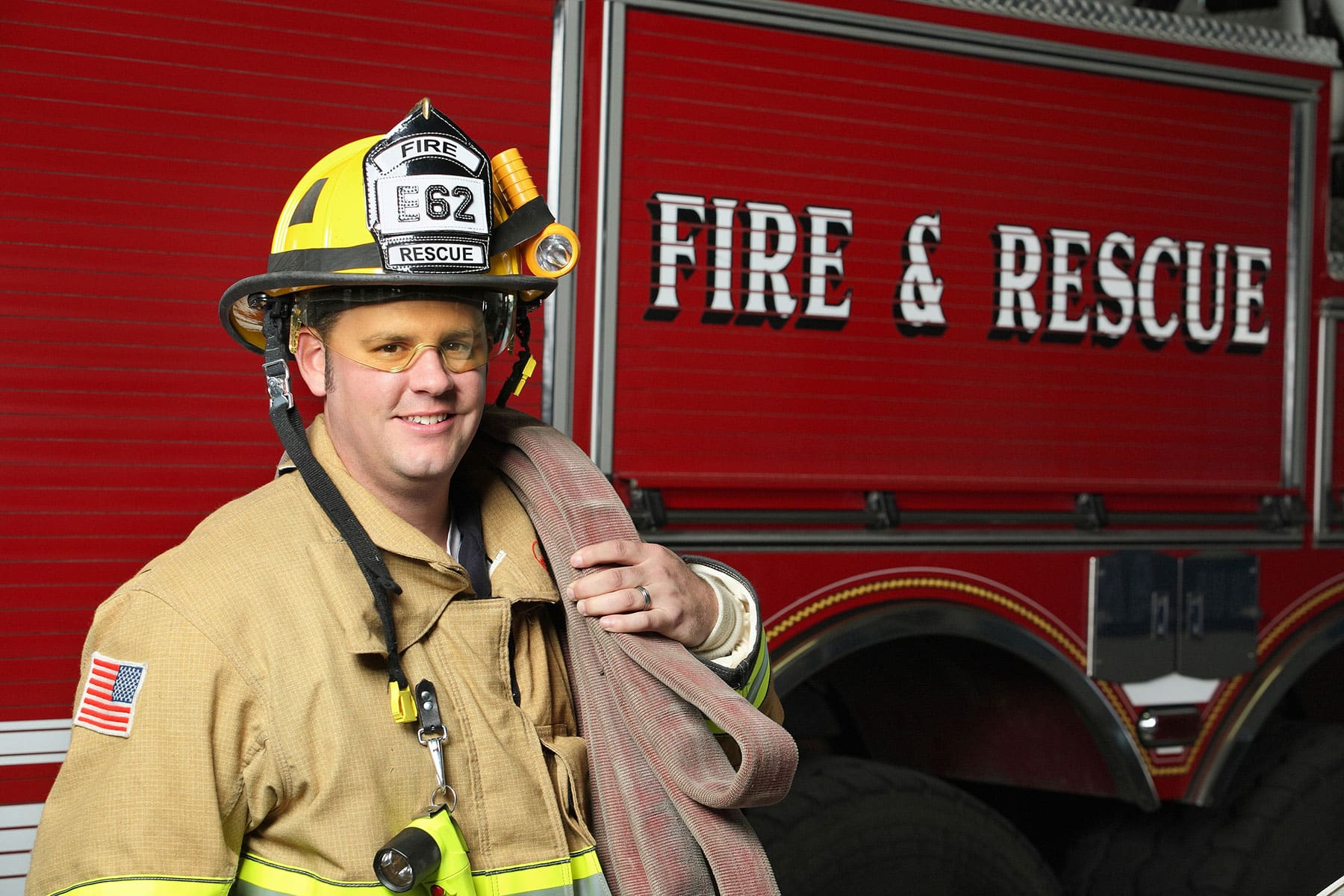 Fire fighter in gear next to a fire truck