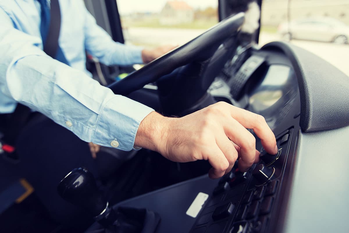 Man driving a large transportation bus