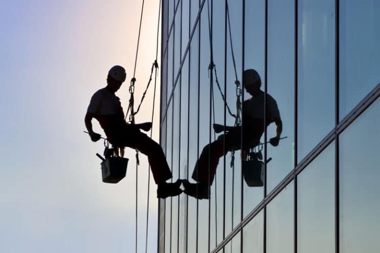 Man on the side of a building with a tool belt