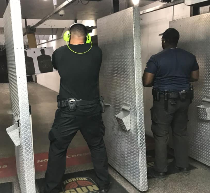Two men shooting at an indoor shooting range