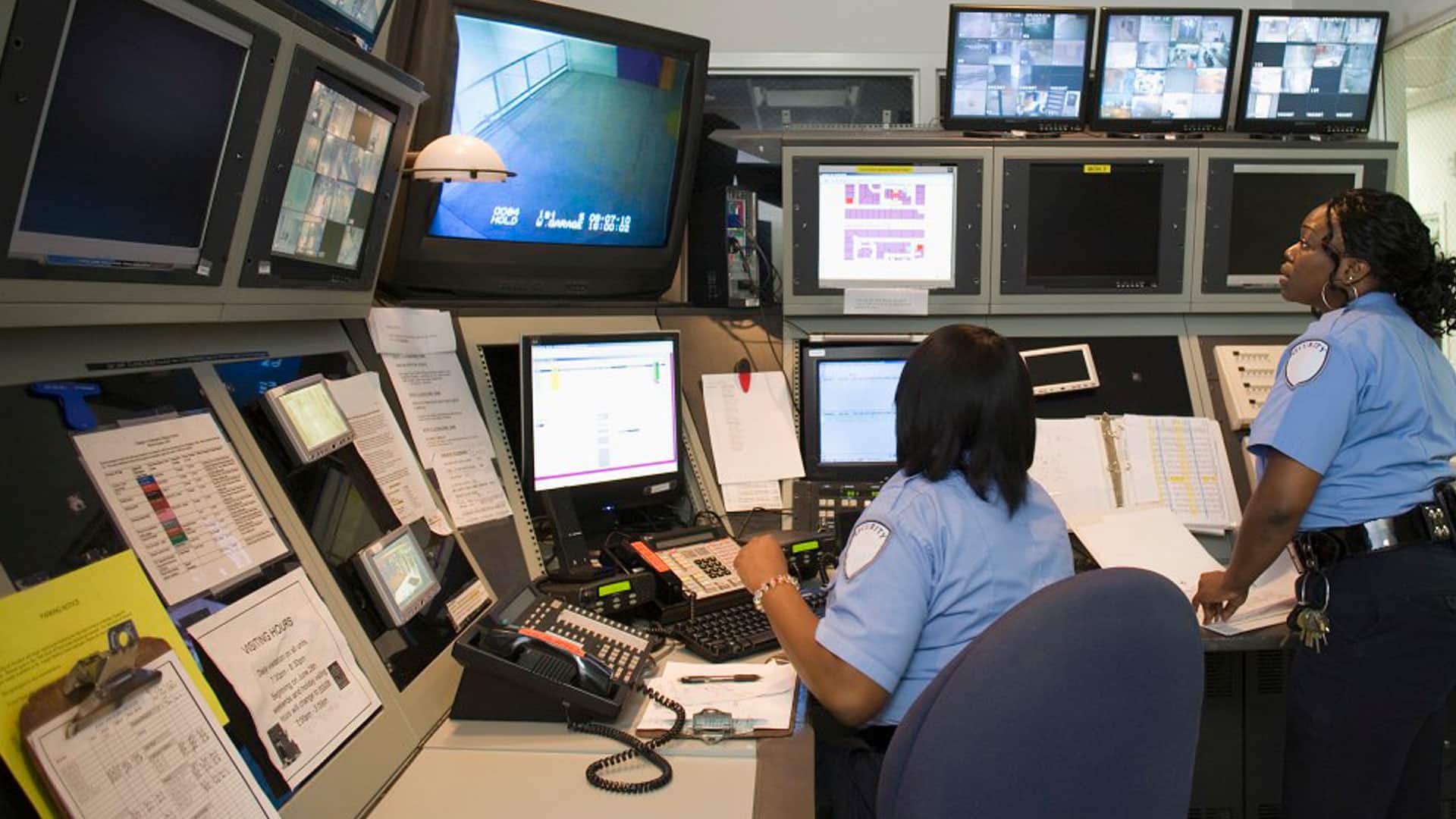 Two security guards watching cameras